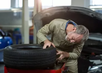 Mechanic examining a tyre in repair garage