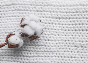 Cotton Flower with knitted cap and scarf, flat lay on marble background, winter style