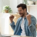 Happy guy celebrate great news opportunity got read by e-mail. Excited man sit in kitchen look at laptop screen with clenched fists feels incredible amazed received good notice. Sale, discount concept