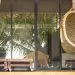 A wicker armchair in the form of a cocoon suspended on the terrace. The recreation scene, the concept of travel and recreation