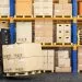 Forklift truck in storage warehouse. Fork lift lifting pallet with cardboard boxes. 3d illustration