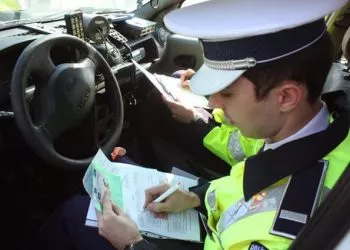 Un angajat al Politiei Rutiere scrie o amenda unui conducator auto, in urma unui control facut impreuna cu reprezentantii RAR, in Craiova, vineri, 14 martie 2014. TIBI BOLOGH / MEDIAFAX FOTO