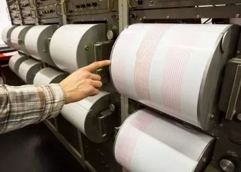 Seismograph records an earthquake on the sheet of measuring paper. Seismological device for measuring earthquakes. Earthquake wave on graph paper. Human finger showing a detail of the earthquake.,Image: 325427777, License: Royalty-free, Restrictions: , Model Release: no