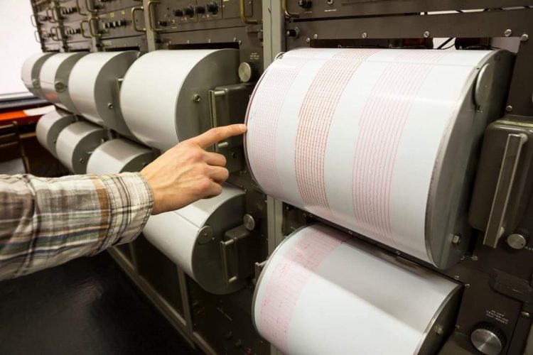 Seismograph records an earthquake on the sheet of measuring paper. Seismological device for measuring earthquakes. Earthquake wave on graph paper. Human finger showing a detail of the earthquake.,Image: 325427777, License: Royalty-free, Restrictions: , Model Release: no