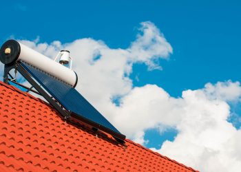 Solar water heater on rooftop, beautiful summer blue sky in the background.