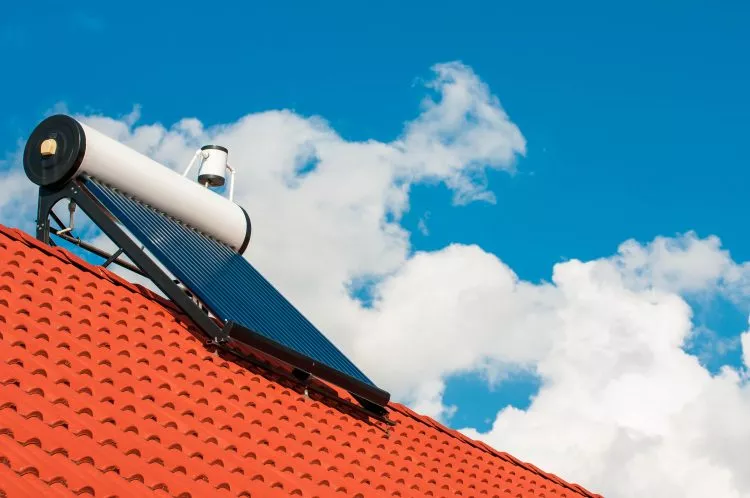 Solar water heater on rooftop, beautiful summer blue sky in the background.