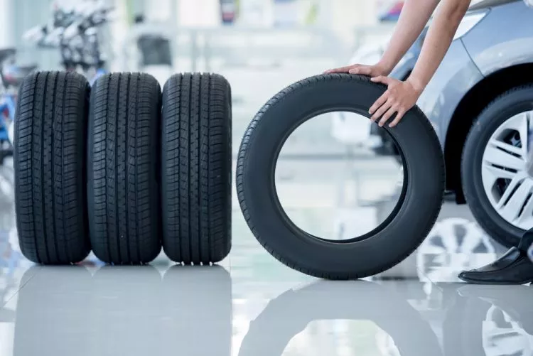 4 new tires that change tires in the auto repair service center, blurred background, the background is a new car in the stock blur for the industry, a four-wheeled tire set at a large warehouse