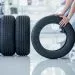4 new tires that change tires in the auto repair service center, blurred background, the background is a new car in the stock blur for the industry, a four-wheeled tire set at a large warehouse