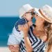 Happy family relaxing by the sea. Happy family resting at beach in summer. mother with baby boy resting on the beach. Young mother and her adorable little daughter on beach vacation