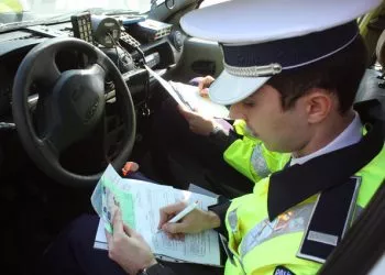Un angajat al Politiei Rutiere scrie o amenda unui conducator auto, in urma unui control facut impreuna cu reprezentantii RAR, in Craiova, vineri, 14 martie 2014. TIBI BOLOGH / MEDIAFAX FOTO