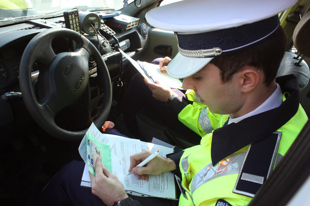 Un angajat al Politiei Rutiere scrie o amenda unui conducator auto, in urma unui control facut impreuna cu reprezentantii RAR, in Craiova, vineri, 14 martie 2014. TIBI BOLOGH / MEDIAFAX FOTO