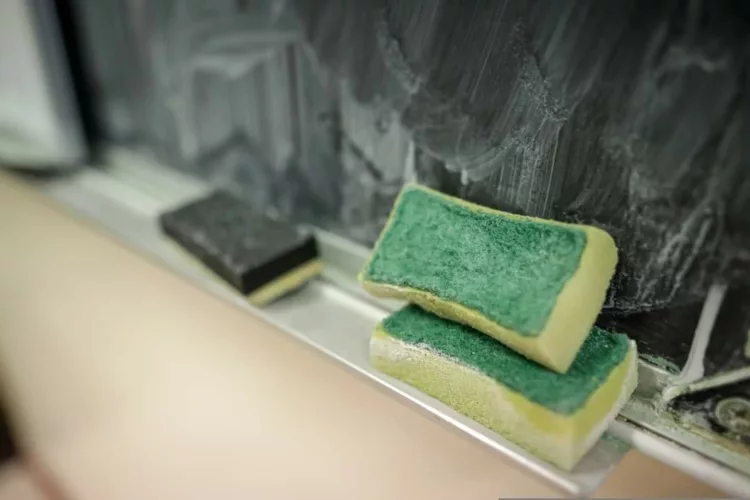 Shallow depth of field (selective focus) details with a sponge used for cleaning the blackboard from chalk in the classroom of a primary school.