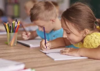 Little girl drawing in her notebook