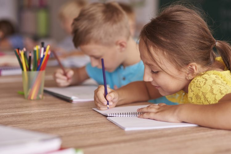 Little girl drawing in her notebook