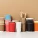 stacks of assorted disposable paper cups for drinks, coffee and tea on a white table. Takeaway beverage container