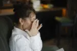Femeie copleșită de durere, cu fața în palme